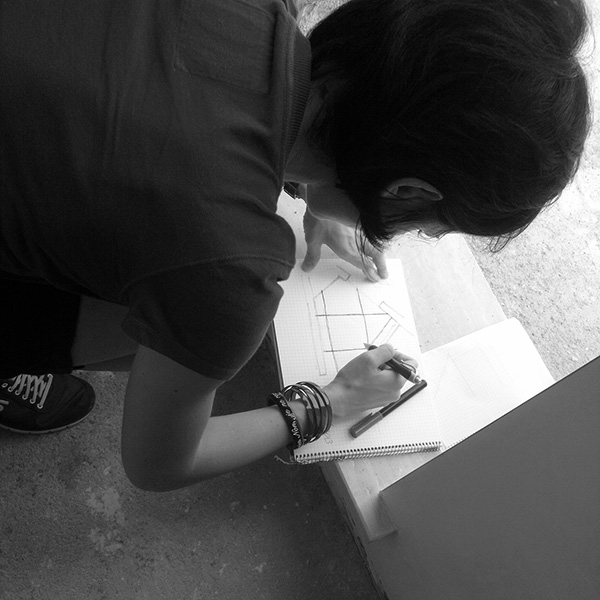Laura draws in a notebook