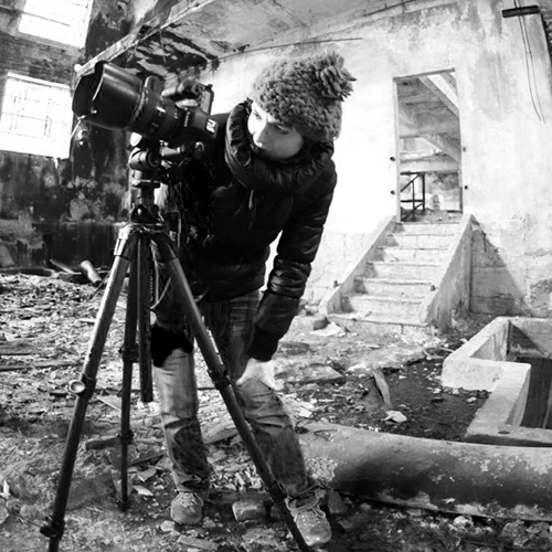 Laura photographing with a tripod inside a ruined building